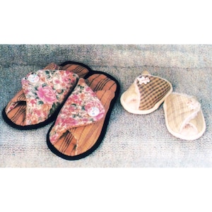 May include: A collection of handmade slippers in various styles. Two pairs of open-toe slippers feature a floral print on the top, with a button detail. The other two pairs are closed-toe slippers with a plaid and patterned design. All have a striped base.