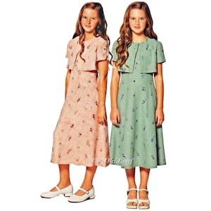 May include: Two young girls wearing matching dresses and boleros. One dress is light pink with a floral pattern, the other is light green with a similar design. Both outfits include matching boleros and white shoes.