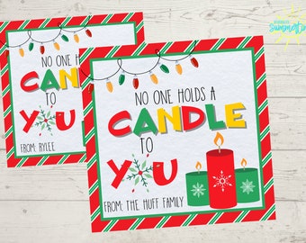 Puede incluir: Dos etiquetas de regalo de Navidad imprimibles con bordes rayados rojos y verdes. La etiqueta superior dice "Nadie sostiene una vela para ti" con un dibujo de velas. La etiqueta inferior dice "Nadie puede para ti" con un dibujo de luces navideñas. Ambas etiquetas tienen un espacio para un nombre.