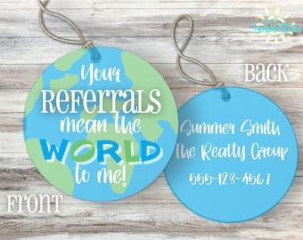 Puede incluir: Una etiqueta redonda azul y verde con el texto "Your Referrals mean the WORLD to me!" en el frente. La parte posterior de la etiqueta tiene el texto "Summer Smith The Realty Group 555-123-4567".