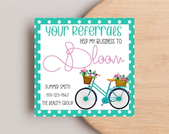 May include: A teal blue and white polka dot card with the text "Your Referrals Help My Business To Bloom" in pink and white. A blue bicycle with flowers in baskets is pictured on the card. The text "Summer Smith 555-123-4567 The Realty Group" is also on the card.