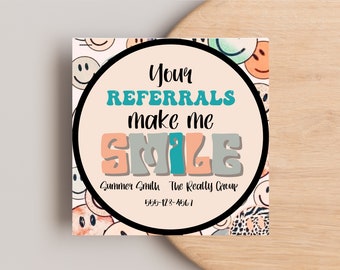 Może przedstawiać: Biała wizytówka z czarnym kółkiem w środku. Kółko ma jasnoróżowe tło z tekstem "Your Referrals make me SMILE" w kolorowej czcionce retro. Tekst "Summer Smith The Realty Group 555-123-4561" znajduje się pod kółkiem. Tło wizytówki jest wypełnione kolorowymi uśmiechniętymi buźkami.