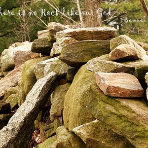 Pu&ograve; includere: Un mucchio di rocce con muschio e licheni che crescono su di esse. Le rocce sono disposte in modo disordinato e alcune sono impilate l'una sull'altra. Il testo "...there is no Rock like our God. 1 Samuel 2:2" &egrave; scritto in corsivo bianco sulle rocce.