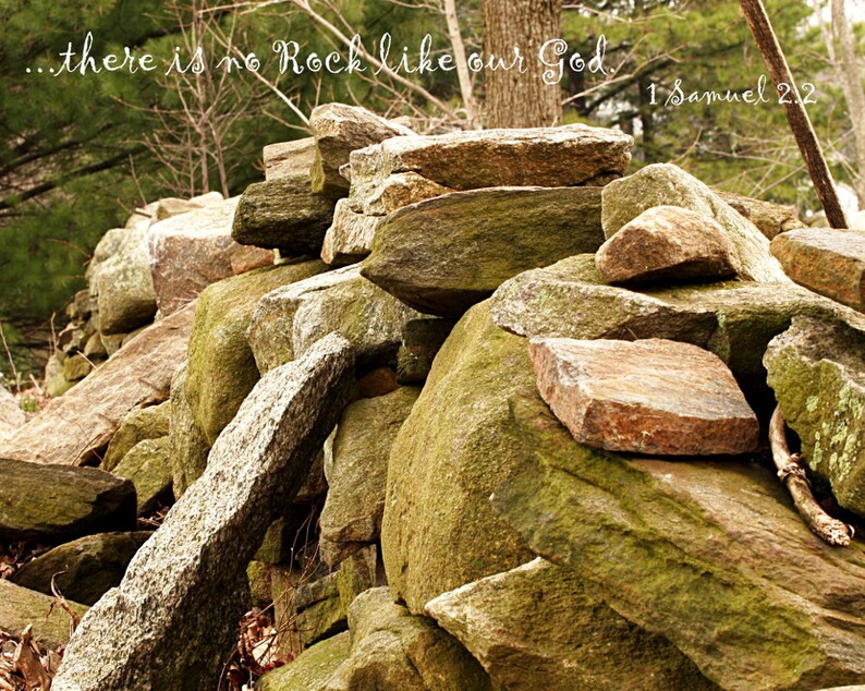 Pu&ograve; includere: Un mucchio di rocce con muschio e licheni che crescono su di esse. Le rocce sono disposte in modo disordinato e alcune sono impilate l'una sull'altra. Il testo "...there is no Rock like our God. 1 Samuel 2:2" &egrave; scritto in corsivo bianco sulle rocce.