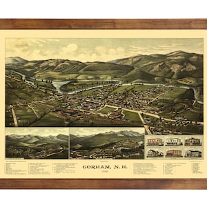 May include: An antique map of Gorham, New Hampshire, printed in 1888. The map shows a bird's-eye view of the town, including the river, buildings, and surrounding hills. The map is framed in a brown wooden frame.