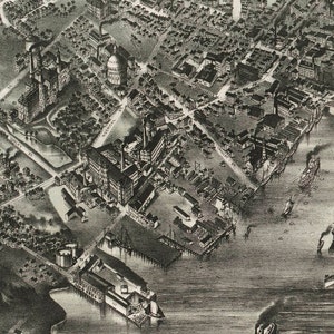 May include: A black and white aerial view of a city with a large industrial complex and a harbor. The complex is made up of many buildings and structures, including a large factory, a warehouse, and a dock. The harbor is filled with ships and boats.