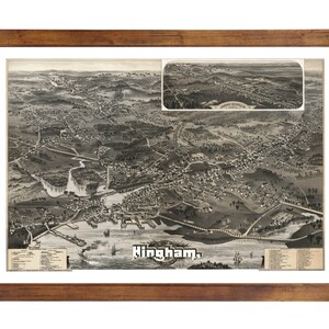 May include: A vintage black and white aerial view map of Hingham, Massachusetts. The map shows the town's streets, buildings, and waterways. The map is framed in a brown wooden frame.