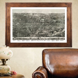 May include: A vintage map of Providence, Rhode Island, framed in a dark wood frame. The map is in black and white and shows the city's streets and buildings.