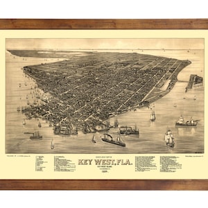 May include: An antique map of Key West, Florida, from 1889. The map shows the city's layout, including streets, buildings, and the surrounding water. The map is framed in a brown wooden frame.