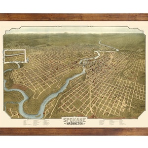 May include: An antique bird's-eye view map of Spokane, Washington. The map shows the city's streets, buildings, and rivers in a detailed, hand-drawn style. The map is framed in a brown wooden frame.