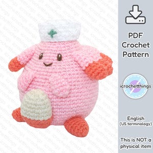 Könnte beinhalten: Ein rosa gehäkeltes Amigurumi-Spielzeug mit einer weißen Krankenschwestermütze und einem grünen Kreuz. Das Spielzeug hat ein lächelndes Gesicht und orangefarbene Arme und Beine. Das Spielzeug ist ein Häkelmuster.