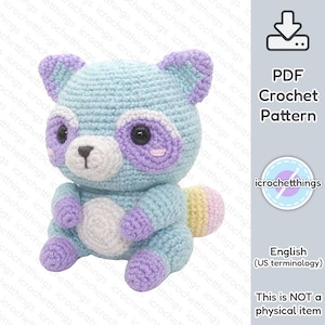 Puede incluir: Un patrón de crochet para un mapache amigurumi azul pastel y morado. El patrón está disponible para descargar en PDF. La imagen incluye el texto "Patrón de crochet PDF" y "Esto NO es un artículo físico".