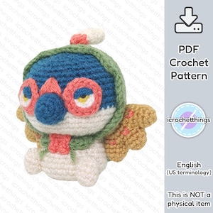 May include: A crochet pattern for a cute, cartoon-style penguin wearing a green and blue hat and a red scarf. The penguin has large, round eyes and a small, orange beak. The pattern is available as a PDF download.