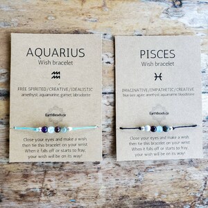 May include: Two cards featuring the zodiac signs Aquarius and Pisces. Each card displays a wish bracelet with assorted coloured beads and a description of the zodiac sign's personality traits. The text on the cards reads "Aquarius Wish Bracelet" and "Pisces Wish Bracelet".