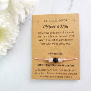 May include: A pink and silver bracelet with a lava stone bead and rose quartz beads. The bracelet comes with a card that says "A Little Wish for Mother's Day" and includes instructions for making a wish. The card also says "Rose Quartz - love & comfort" and "Aromatherapy Diffuser Bracelet - add a drop of essential oil to lava stone, rub in and let absorb before wearing."