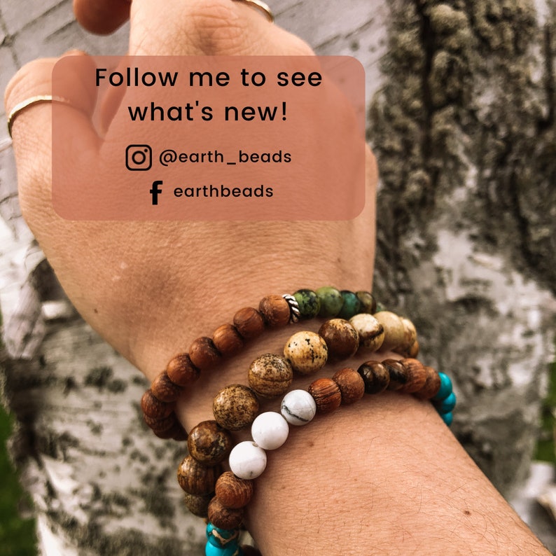 May include: A person's wrist wearing four beaded bracelets. The bracelets are made of wood, stone, and turquoise. The text "Follow me to see what's new! @earth_beads f earthbeads" is visible in the image.