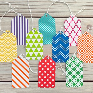 May include: Ten colourful gift tags with different geometric patterns. The tags are made of paper and have a string attached to them. The patterns include stripes, polka dots, zigzags, and more.