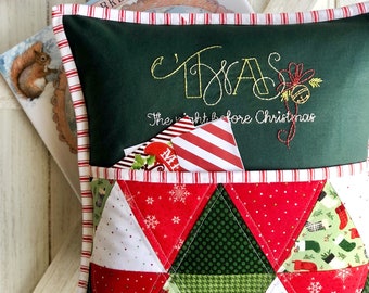 May include: A green pillow with red and white striped trim. The pillow has a pocket on the front with a patchwork design of red, green, and white fabric. The pillow is embroidered with the text "Twas the night before Christmas".