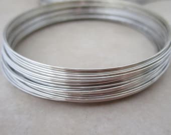 May include: A close-up of a stack of silver wire, perfect for jewelry making or crafting projects.