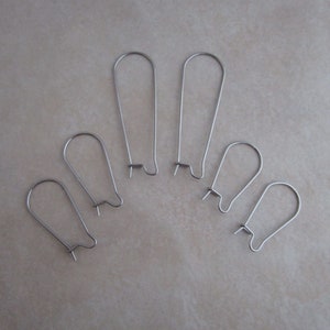 May include: Six silver earring hooks of varying sizes. The hooks are made of metal and have a simple, classic design.
