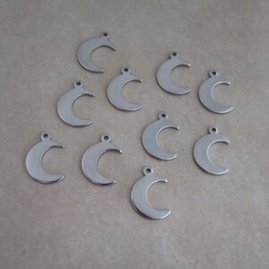 May include: Ten silver crescent moon charms with a loop at the top for attaching to jewelry or other crafts.