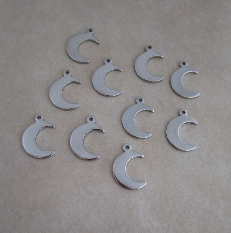 May include: Ten silver crescent moon charms with a loop at the top for attaching to jewelry or other crafts.