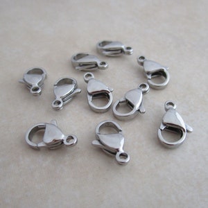 May include: Ten silver-toned lobster clasps, a type of fastener used for jewelry making.