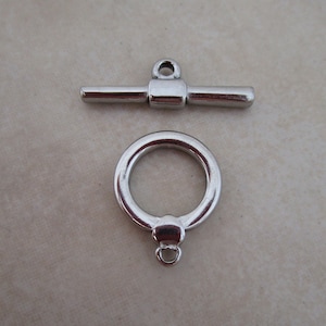 May include: Silver-toned metal toggle clasp with a round ring and a bar with a loop at the top.