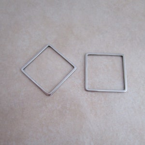 May include: Two silver metal frames, one square and one diamond shaped.