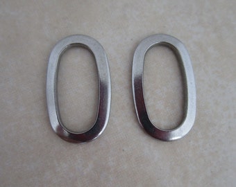 May include: Two silver metal rings, each with a circular opening. The rings are smooth and shiny.