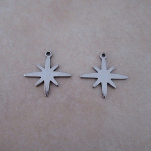 May include: Two silver star-shaped charms with a loop at the top for attaching to jewelry or other crafts.