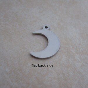 May include: Silver crescent moon charm with a flat back side.