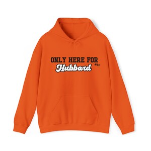 May include: Orange hoodie with a white and black graphic that says "ONLY HERE FOR Hubbard #94".