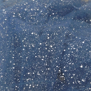 Puede incluir: Tela de tul azul con puntos de purpurina plateados. La tela tiene una textura suave y delicada, perfecta para manualidades y proyectos de bricolaje.
