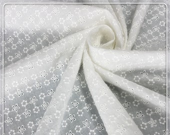 May include: White cotton fabric with a delicate eyelet pattern. The fabric is sheer and has a soft, drapey texture.