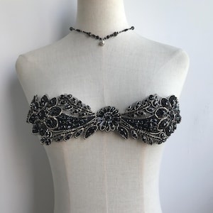 May include: Black beaded embellishment with gold thread, ideal for adding a touch of elegance to clothing or accessories.