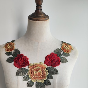 May include: A floral applique featuring three red and yellow roses with green leaves. This applique is ideal for adding a touch of elegance to clothing, bags, or home decor projects.