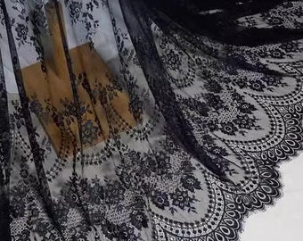 May include: Black lace fabric with a scalloped edge and floral pattern.