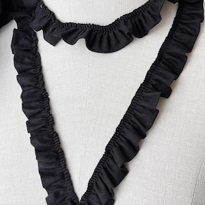 Puede incluir: Borde negro con volantes con un diseño delicado y fruncido. Este borde es perfecto para agregar un toque de elegancia a cualquier proyecto.