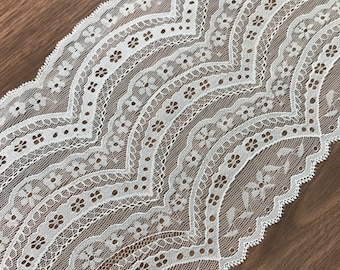 May include: White lace trim with a scalloped edge and a delicate floral pattern.