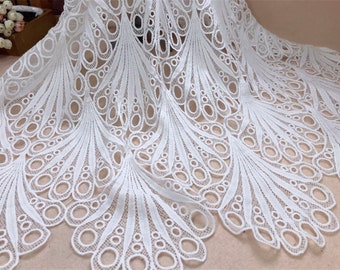 May include: White lace fabric with a detailed peacock feather design. The fabric features a repeating pattern of open circles and curved lines, creating a delicate and airy texture. Ideal for crafting, sewing, or adding a decorative touch to garments.