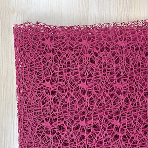 May include: A close-up of a deep pink, delicate, mesh fabric with a fine, intricate pattern. The fabric is soft and airy, with a slightly textured surface.