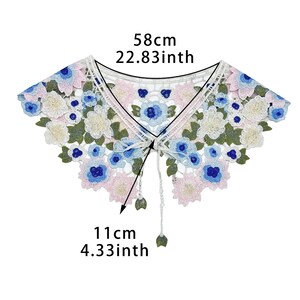 May include: White lace collar with blue and pink floral embroidery. The collar measures 58 cm in length and 11 cm in height.