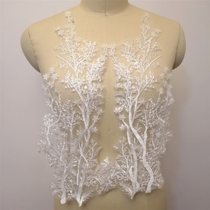 Puede incluir: Aplique de encaje blanco con un delicado diseño de árbol. El encaje está adornado con lentejuelas y es perfecto para agregar un toque de elegancia a cualquier prenda.