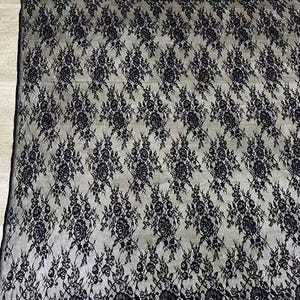 May include: Black lace fabric with a floral pattern. The lace has a scalloped edge.
