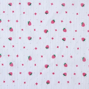 May include: White fabric with a repeating pattern of pink strawberries and small pink flowers.