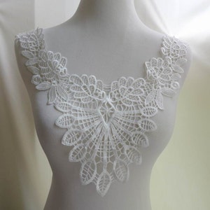 Pu&ograve; includere: Bordino in pizzo bianco con un bordo a festoni e un delicato motivo floreale. Questo bordino &egrave; perfetto per aggiungere un tocco di eleganza a qualsiasi progetto.