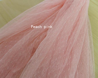 Könnte beinhalten: Peachfarbener Tüllstoff mit Punkten. Der Stoff ist weich und zart, perfekt für Bastel- und Nähprojekte.