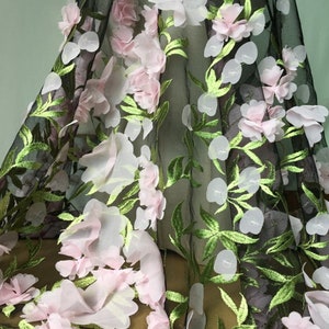 May include: Black tulle fabric with pink and white 3D floral embroidery. The flowers are layered and have a delicate, feminine look.