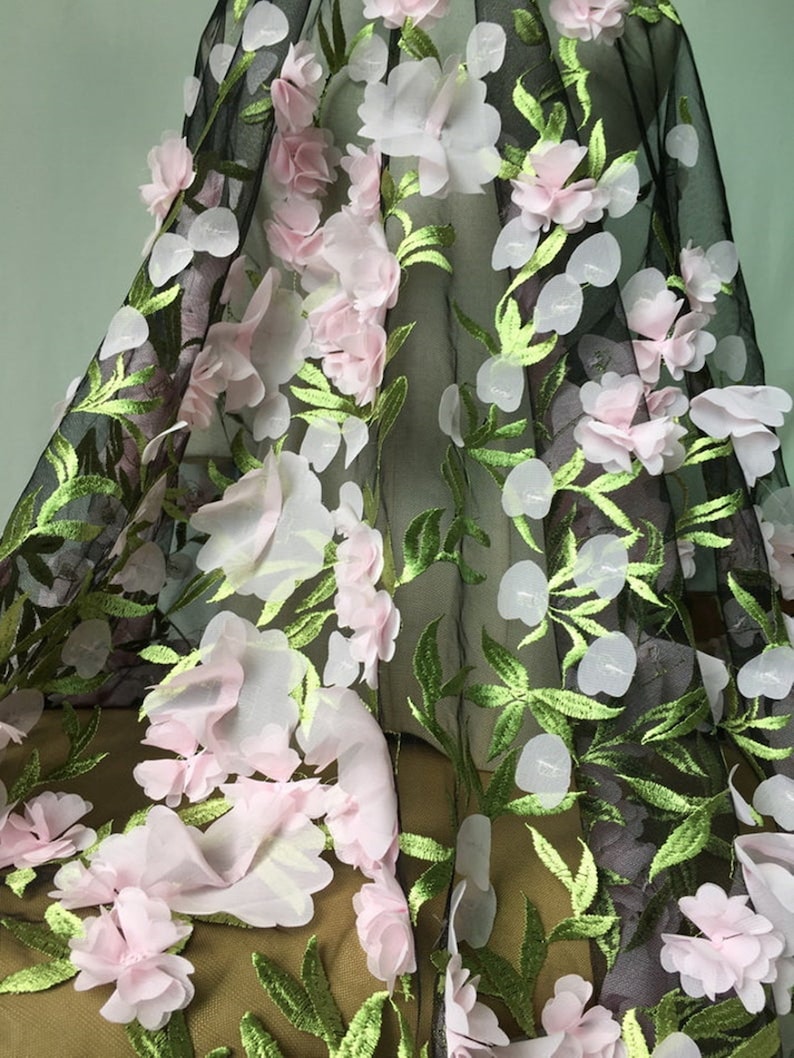 May include: Black tulle fabric with pink and white 3D floral embroidery. The flowers are layered and have a delicate, feminine look.